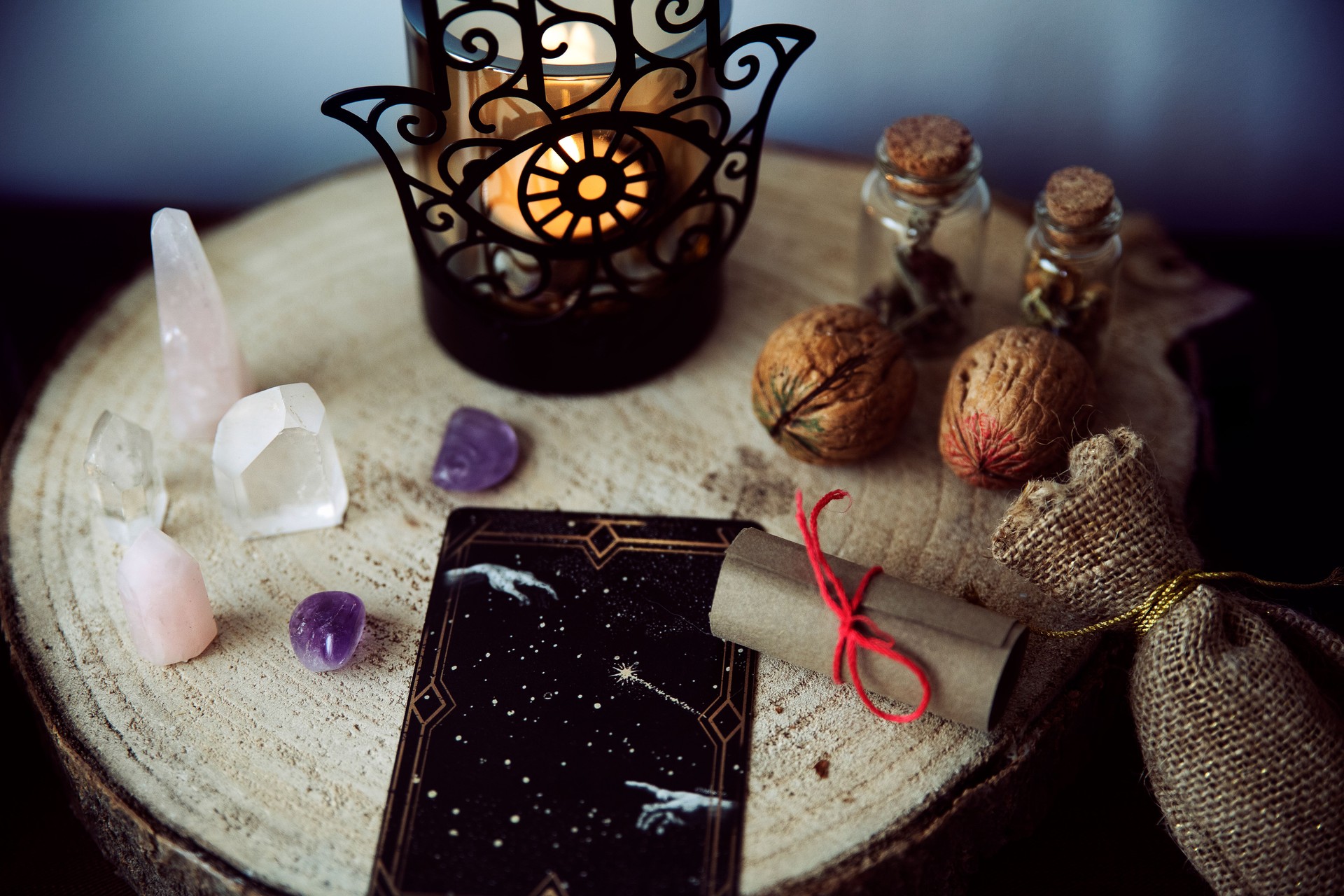 Witch altar to perform rituals with crystals, two walnuts, a scroll with a spell and tarot cards.